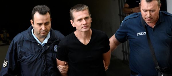 Alexander Vinnik, a 38 year old Russian man suspected of running a money laundering operation using bitcoin, is escorted by police officers while leaving a court in Thessaloniki, Greece, October 4, 2017 - Sputnik International