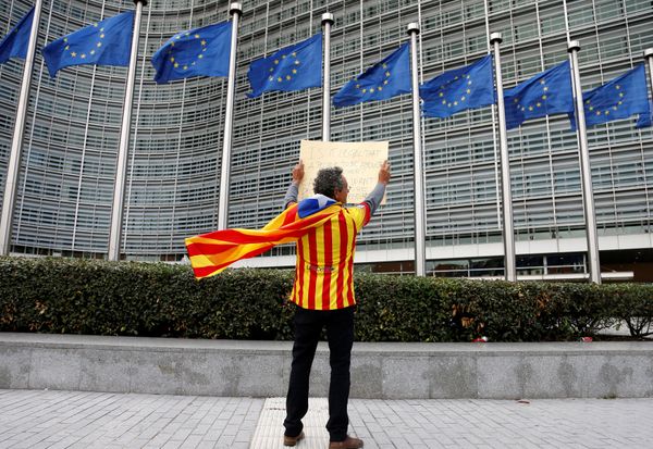Catalan Raimon Castellvi, wearing a flag with an Estelada (Catalan separatist flag), holds a sign as he protests outside the European Commission in Brussels after Sunday's independence referendum in Catalonia, Belgium October 2, 2017 - Sputnik International