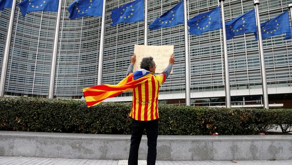 Catalan Raimon Castellvi, wearing a flag with an Estelada (Catalan separatist flag), holds a sign as he protests outside the European Commission in Brussels after Sunday's independence referendum in Catalonia, Belgium October 2, 2017 - Sputnik International