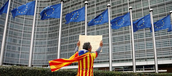 Catalan Raimon Castellvi, wearing a flag with an Estelada (Catalan separatist flag), holds a sign as he protests outside the European Commission in Brussels after Sunday's independence referendum in Catalonia, Belgium October 2, 2017 - Sputnik International