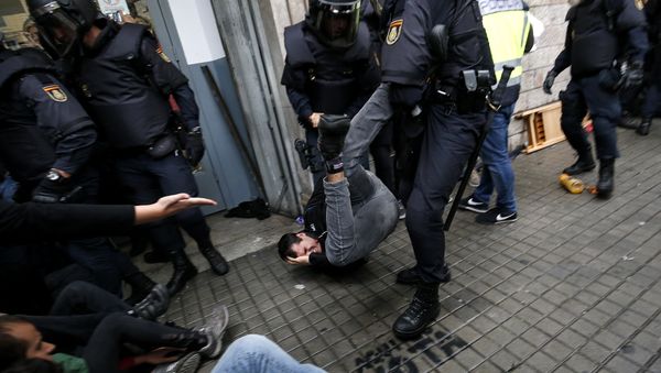 Spanish police officers drag a man as they try to disperse voters arriving to a polling station in Barcelona, on October 1, 2017 during a referendum on independence for Catalonia banned by Madrid Spanish police officers drag a man as they try to disperse voters arriving to a polling station in Barcelona, on October 1, 2017 during a referendum on independence for Catalonia banned by Madrid - Sputnik International