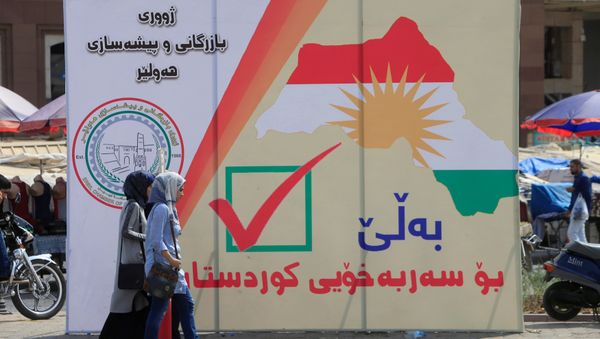 Iraqi women walk on the street, near banners supporting the referendum for independence for Kurdistan in Erbil, Iraq September 21, 2017 - Sputnik International