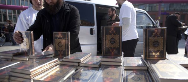 Members of a Muslim group pile Qurans while distributing copies of it at Potsdamer Platz in Berlin. (File) - Sputnik International