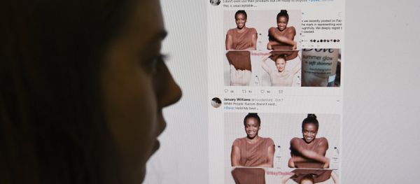 A posed picture taken in London on October 9, 2017 shows a journalist looking at screenshots retweeted by Twitter users on the social networking site of a video-clip used in an online advert by the personal care brand Dove that originally appeared on social networking website Facebook and has since been removed amid accusations of racism - Sputnik International