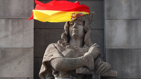 A Spanish flag hangs over the face of a figure representing one of the four realms of Spain on the statue to Columbus in Barcelona, Spain, October 11, 2017. - Sputnik International