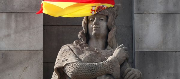 A Spanish flag hangs over the face of a figure representing one of the four realms of Spain on the statue to Columbus in Barcelona, Spain, October 11, 2017. - Sputnik International
