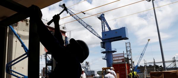 A worker uses a hammer at the exit of the hanger of HMS Queen Elizabeth, the first of two aircraft carriers being built by British defence firm BAE Systems, at the Rosyth Dockyard in Fife, Scotland June 17, 2014 - Sputnik International