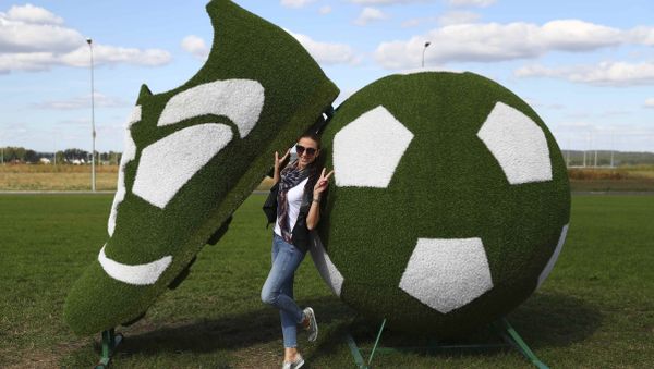 A woman poses for a picture near a decorative sculpture, depicting a ball and a soccer boot, near a terminal of Kurumoch International Airport outside Samara, the host city for the 2018 FIFA World Cup, Russia, September 17, 2017 A woman poses for a picture near a decorative sculpture, depicting a ball and a soccer boot, near a terminal of Kurumoch International Airport outside Samara, the host city for the 2018 FIFA World Cup, Russia, September 17, 2017 - Sputnik International