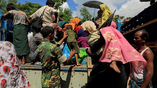 A military member helps a Rohingya refugee boy who arrived from Myanmar to get onto a truck that will take him to a refugee camp from a relief centre in Teknaf, near Cox's Bazar in Bangladesh, October 13, 2017 A military member helps a Rohingya refugee boy who arrived from Myanmar to get onto a truck that will take him to a refugee camp from a relief centre in Teknaf, near Cox's Bazar in Bangladesh, October 13, 2017 - Sputnik International
