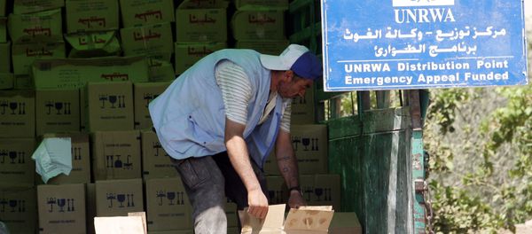A Palestinian worker unloads boxes as provisions are by the United Nations Relief and Works Agency for Palestine Refugees in the Near East (UNRWA). (File) - Sputnik International
