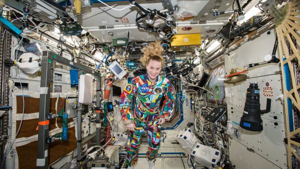 This undated handout photo from NASA shows astronaut Kate Rubins aboard the International Space Station wearing a hand-painted spacesuit decorated by childhood cancer patients at the University of Texas MD Anderson Cancer Center in Houston. NASA said Rubins will chat from the space station with patients during a 20-minute call on Friday, Sept. 16, 2016 - Sputnik International
