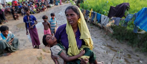 A Rohingya refugee woman who crossed the border from Myanmar a day before, carries her daughter and searches for help as they wait to receive permission from the Bangladeshi army to continue their way to the refugee camps, in Palang Khali, Bangladesh October 17, 2017 A Rohingya refugee woman who crossed the border from Myanmar a day before, carries her daughter and searches for help as they wait to receive permission from the Bangladeshi army to continue their way to the refugee camps, in Palang Khali, Bangladesh October 17, 2017 - Sputnik International