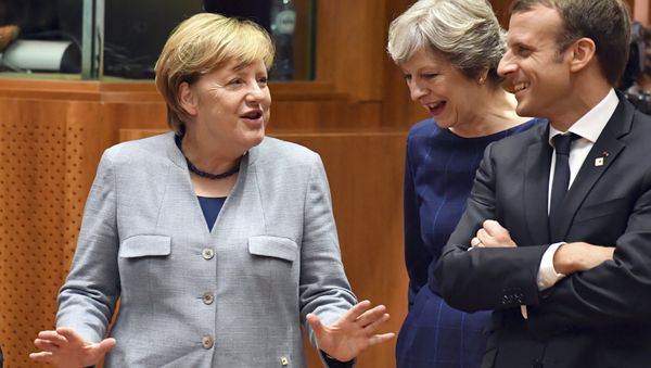German Chancellor Angela Merkel, left, speaks with British Prime Minister Theresa May, center, and French President Emmanuel Macron prior to a round table meeting at an EU summit in Brussels on Thursday, Oct. 19, 2017. - Sputnik International