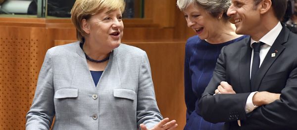 German Chancellor Angela Merkel, left, speaks with British Prime Minister Theresa May, center, and French President Emmanuel Macron prior to a round table meeting at an EU summit in Brussels on Thursday, Oct. 19, 2017. German Chancellor Angela Merkel, left, speaks with British Prime Minister Theresa May, center, and French President Emmanuel Macron prior to a round table meeting at an EU summit in Brussels on Thursday, Oct. 19, 2017. - Sputnik International