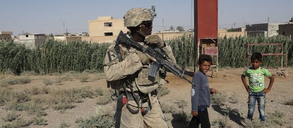 A U.S. soldier stands near Syrian children on a road that links to Raqqa, Syria, Wednesday, July 26, 2017 - Sputnik International