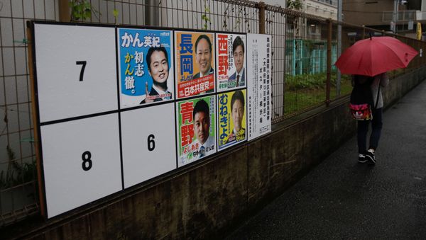 A woman walks in the rain past election posters as Typhoon Lan approaches Japan's mainland, in Osaka, western Japan, October 22, 2017 - Sputnik International