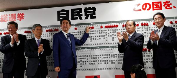Japan's Prime Minister Shinzo Abe, leader of the Liberal Democratic Party (LDP), puts a rosette on the name of a candidate who is expected to win the lower house election, as his party's lawmakers applaud at the LDP headquarters in Tokyo, Japan October 22, 2017 Japan's Prime Minister Shinzo Abe, leader of the Liberal Democratic Party (LDP), puts a rosette on the name of a candidate who is expected to win the lower house election, as his party's lawmakers applaud at the LDP headquarters in Tokyo, Japan October 22, 2017 - Sputnik International