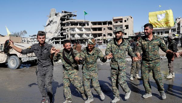 Fighters of Syrian Democratic Forces dance along a street in Raqqa, Syria October 18, 2017. - Sputnik International
