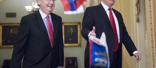 Small Russian flags bearing the word Trump are thrown by a protester toward President Donald Trump, as he walks with Senate Majority Leader Mitch McConnell, R-Ky., on Capitol Hill to have lunch with Senate Republicans and push for his tax reform agenda, in Washington, Tuesday, Oct. 24, 2017 - Sputnik International