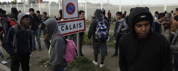 In this Thursday, Oct. 27, 2016 file photo migrants gather near a fence in Calais, northern France. - Sputnik International