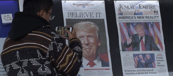 Zheng Gao of Shanghi, China, photographs the front pages of newspapers on display outside the Newseum in Washington, Wednesday, Nov., 9, 2016 - Sputnik International