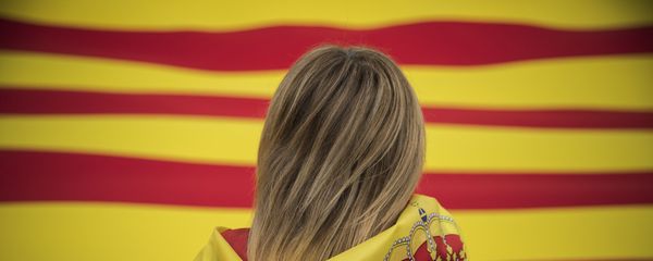 A woman wearing a Spanish flag on her shoulders looks at a giant flag of Catalonia as people celebrate a holiday known as Dia de la Hispanidad or Spain's National Day in Barcelona, Spain, Thursday, Oct. 12, 2017. A woman wearing a Spanish flag on her shoulders looks at a giant flag of Catalonia as people celebrate a holiday known as Dia de la Hispanidad or Spain's National Day in Barcelona, Spain, Thursday, Oct. 12, 2017. - Sputnik International