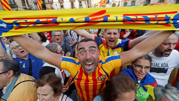 A man displays a scarf featuring an Estelada (Catalan separatist flag) design, as he reacts at Sant Jaume Square after the Catalan regional parliament declares independence from Spain in Barcelona, Spain October 27, 2017. - Sputnik International