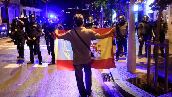 A pro unity demonstrator displays a Spanish flag to Catalan Regional Police officers during a protest after the Catalan regional parliament declared independence from Spain in Barcelona, Spain, October 27, 2017 - Sputnik International