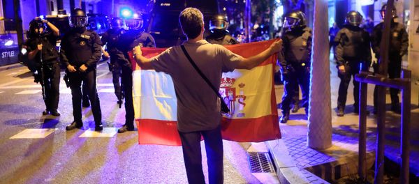 A pro unity demonstrator displays a Spanish flag to Catalan Regional Police officers during a protest after the Catalan regional parliament declared independence from Spain in Barcelona, Spain, October 27, 2017 A pro unity demonstrator displays a Spanish flag to Catalan Regional Police officers during a protest after the Catalan regional parliament declared independence from Spain in Barcelona, Spain, October 27, 2017 - Sputnik International