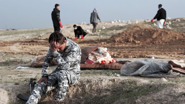 An Iraqi policeman collects himself at the burial site for bodies found in a mass grave containing some two dozen people, many of them children, in an area recently re-taken from Islamic State militants in Hamam al-Alil, Iraq, Wednesday, March 15, 2017 - Sputnik International