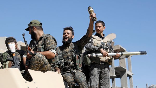 Fighters of Syrian Democratic Forces jubilate aboard an armoured fighting vehicle after Raqqa was liberated from the Islamic State militants, in Raqqa, Syria October 17, 2017 - Sputnik International