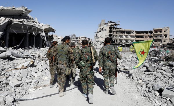 Fighters of Syrian Democratic Forces walk past the ruins of destroyed buildings near the National Hospital after Raqqa was liberated from the Islamic State militants, in Raqqa, Syria October 17, 2017. Picture taken October 17, 2017 - Sputnik International
