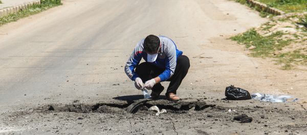 A Syrian man collects samples from the site of a suspected toxic gas attack in Khan Sheikhun, in Syria’s northwestern Idlib province, on April 5, 2017 - Sputnik International