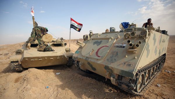 Iraqi forces and members of the Hashed al-Shaabi (Popular Mobilisation units) advance towards the city of al-Qaim, in western Anbar province, on the Syrian border as they fight against remnant pockets of Islamic State group jihadists on November 2, 2017 - Sputnik International