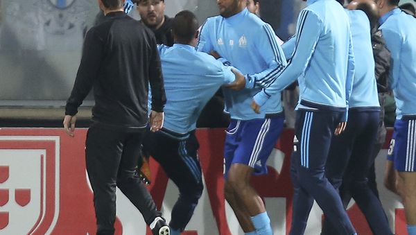 Marseille's Patrice Evra, third left, raises his foot trying to kick a man during a scuffle with Marseille supporters who trespassed into the field before the Europa League group I soccer match between Vitoria SC and Olympique de Marseille at the D. Afonso Henriques stadium in Guimaraes, Portugal, Thursday, Nov. 2, 2017. - Sputnik International