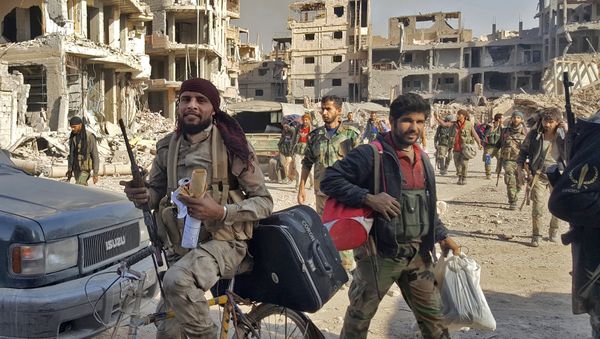 Syrian soldiers, and pro-government forces, are seen in front of damaged buildings in the eastern Syrian city of Deir Ezzor on November 3, 2017 - Sputnik International