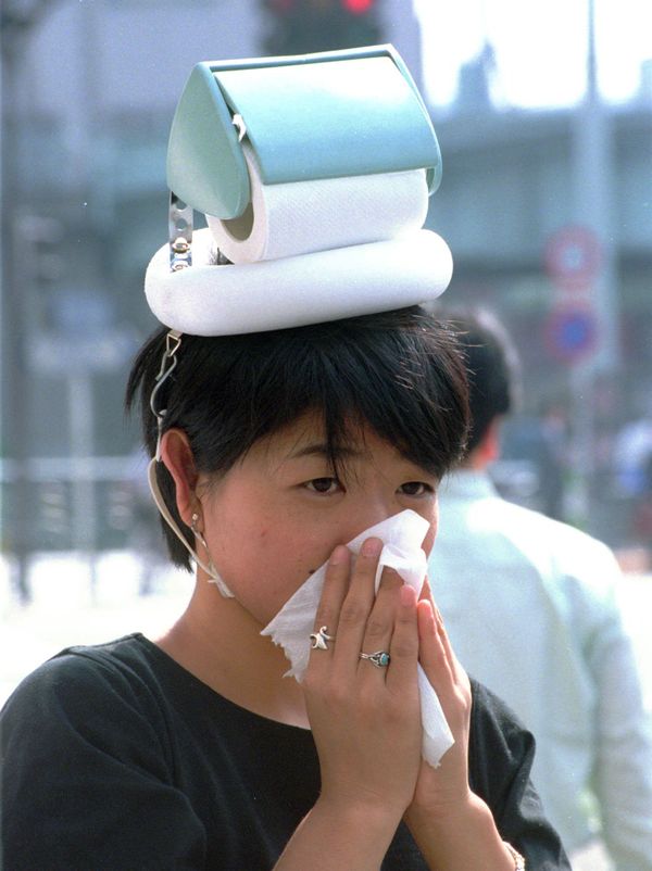 A woman wearing a Hay Fever Hat, the all day tissue dispenser, blows nose on a Tokyo street Thursday, Oct. 19. 1995 - Sputnik International