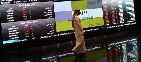 Saudi investor walking past the stock exchange monitors at the Saudi Stock Exchange, or Tadawul, in the capital Riyadh (File) Saudi investor walking past the stock exchange monitors at the Saudi Stock Exchange, or Tadawul, in the capital Riyadh (File) - Sputnik International