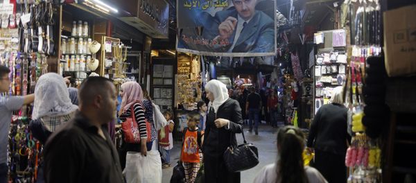 In this May 18, 2017 photo, Syrians shop under a banner showing President Bashar Assad at the Hamadiyah market, in the Old City of Damascus, Syria. In this May 18, 2017 photo, Syrians shop under a banner showing President Bashar Assad at the Hamadiyah market, in the Old City of Damascus, Syria. - Sputnik International
