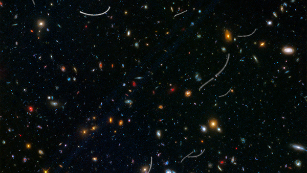 This Hubble photo of a random patch of sky is part of a survey called Frontier Fields. Asteroid trails appear as curved or S-shaped streaks. - Sputnik International