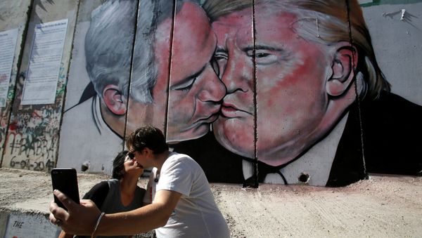 Tourists kissing in front of Trump-Netanyahu Mural - Sputnik International
