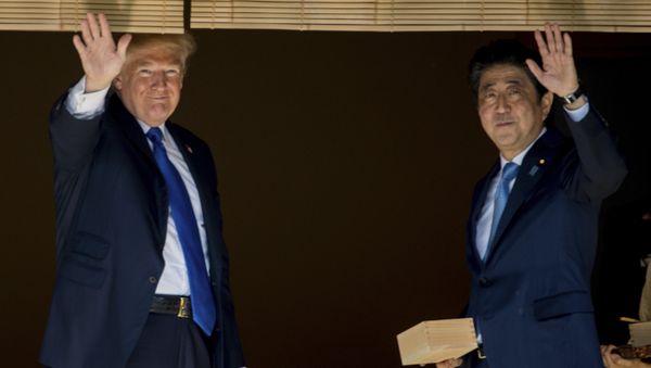 President Donald Trump and Japanese Prime Minister Shinzo Abe wave to members of the media after feeding fish at a koi pond at the Akasaka Palace, Monday, Nov. 6, 2017, in Tokyo. - Sputnik International