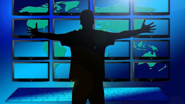 A silhouette of a man in front of multiple screens - Sputnik International