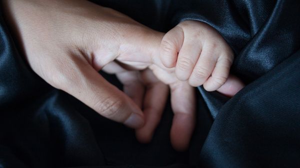 An adult holding a baby's hand An adult holding a baby's hand - Sputnik International
