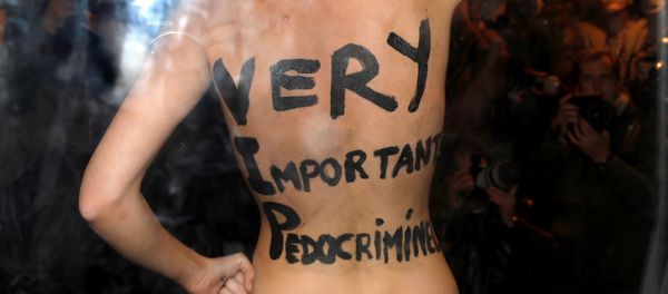 A feminist protester from the Femen group reveals messages written on her body upon the arrival of director Roman Polanski at an event organised by Cinematheque Francaise in Paris, France, October 30, 2017. - Sputnik International