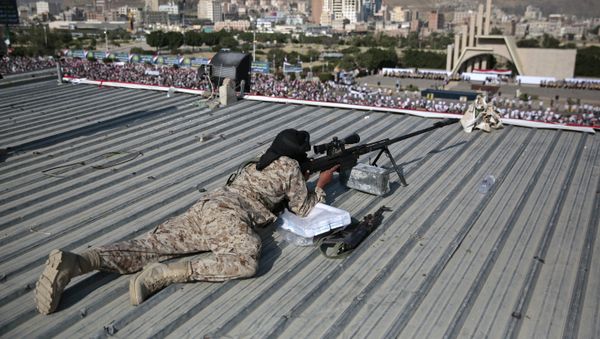 A Houthi Shiite sniper keeps watch over a rally to mark the third anniversary of the Houthis' takeover of the Yemeni capital, in Sanaa. - Sputnik International