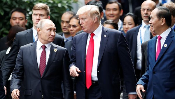 U.S. President Donald Trump and Russia's President Vladimir Putin talk as Vietnam's President Tran Dai Quang (R) looks on, during the family photo session at the APEC Summit in Danang, Vietnam November 11, 2017 - Sputnik International