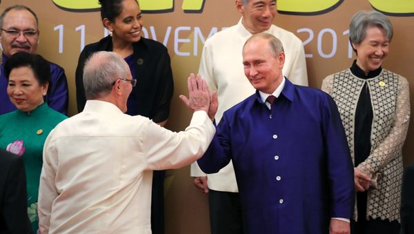 Russian President Vladimir Putin poses for a family photo in traditional Vietnamese clothes during the APEC Economic Leaders’ Meeting in Vietnam - Sputnik International