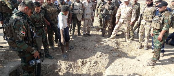 Iraqi forces search the site of a suspected mass grave containing the remains of victims of the Islamic State group, near the former al bakara military base on November 11, 2017, south west of Hawija Iraqi forces search the site of a suspected mass grave containing the remains of victims of the Islamic State group, near the former al bakara military base on November 11, 2017, south west of Hawija - Sputnik International