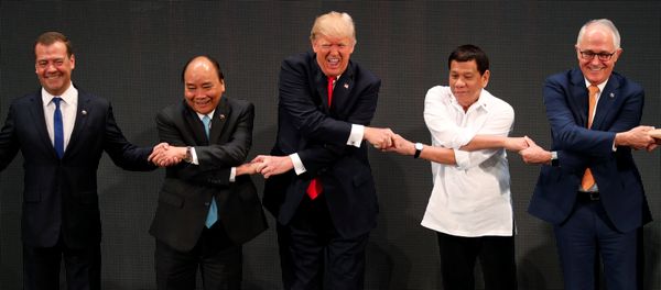 U.S. President Donald Trump smiles with other leaders, including Russia's Prime Minister Dmitry Medvedev, Vietnam's Prime Minister Nguyen Xuan Phuc, President of the Philippines Rodrigo Duterte and Australia's Prime Minister Malcolm Turnbull, as they cross their arms for the traditional ASEAN handshake in the opening ceremony of the ASEAN Summit in Manila, Philippines November 13, 2017 U.S. President Donald Trump smiles with other leaders, including Russia's Prime Minister Dmitry Medvedev, Vietnam's Prime Minister Nguyen Xuan Phuc, President of the Philippines Rodrigo Duterte and Australia's Prime Minister Malcolm Turnbull, as they cross their arms for the traditional ASEAN handshake in the opening ceremony of the ASEAN Summit in Manila, Philippines November 13, 2017 - Sputnik International